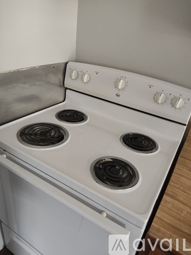 A white stove top with four burners and knobs for temperature control.