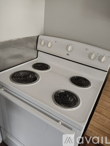 A white stove top with four burners and knobs for temperature control.