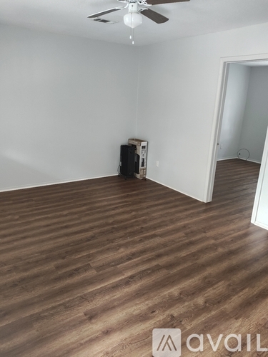 A room with wooden flooring and a ceiling fan.