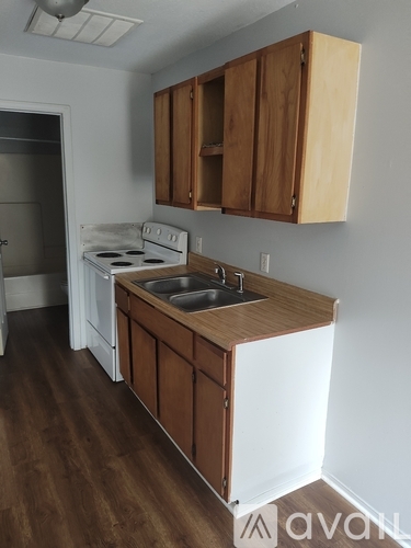 A kitchen with wooden cabinets and a white stove.