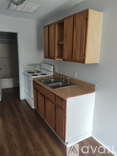 A kitchen with wooden cabinets and a white stove.