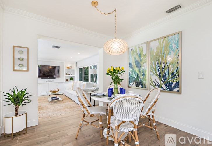 A dining room with a white table and chairs.
