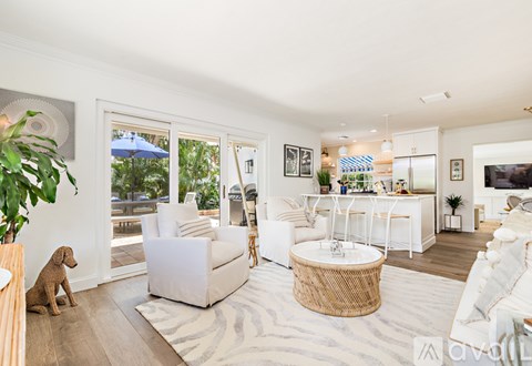A living room with a white couch and a dog.