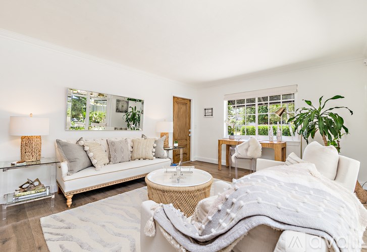 A well-lit, spacious bedroom with a large bed and a couch.