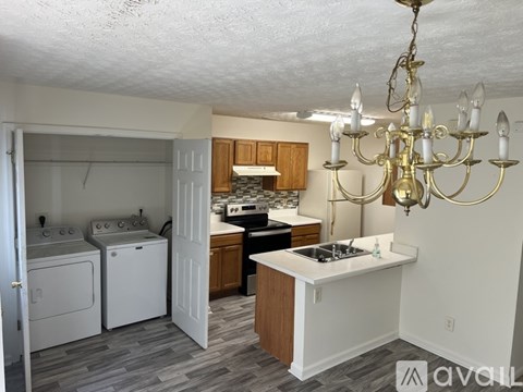 A kitchen with a white countertop and a chandelier.