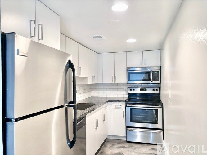 A modern kitchen with stainless steel appliances and white cabinets.