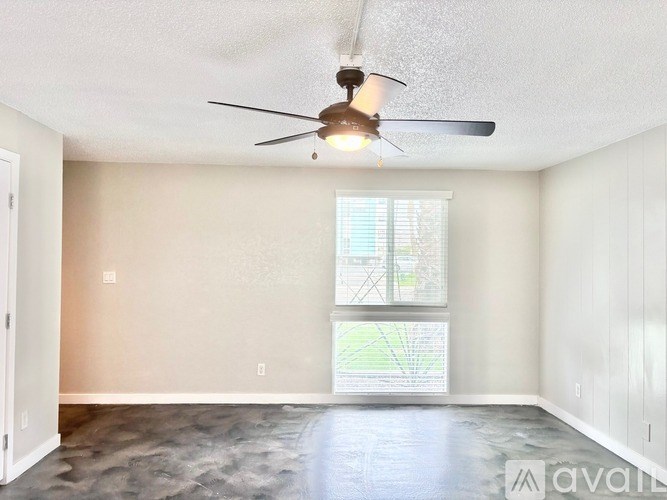 A room with a ceiling fan and a window.