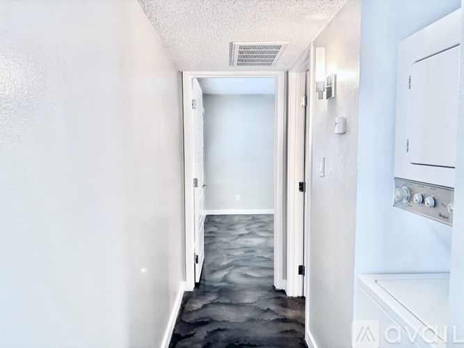 A hallway with a black floor and white walls.