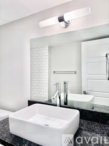 A white sink in a black counter top bathroom.