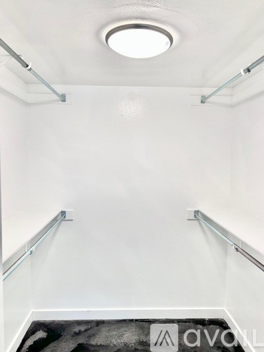 A white room with a black and white rug on the floor.