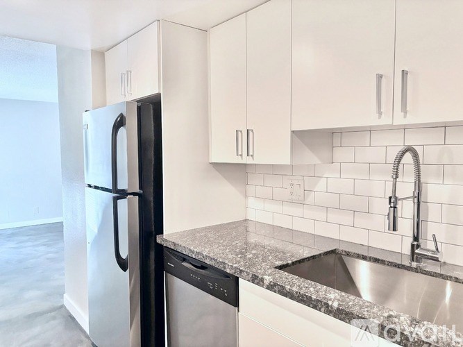 A kitchen with a black fridge and a black dishwasher.