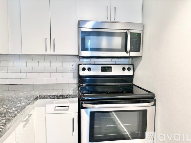 A modern kitchen with a stove top oven and microwave above it.