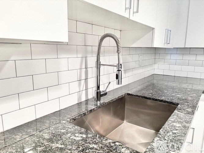 A kitchen sink with a chrome faucet and a chrome sink.