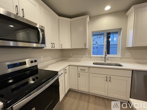 A kitchen with white cabinets and a black stove top.