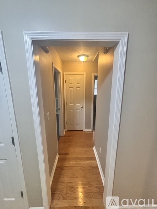 A hallway with a door at the end.