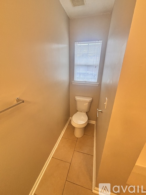 A small bathroom with a toilet and a window.