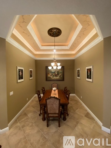 A dining room with a wooden table and chairs.