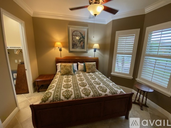A bedroom with a large bed and a ceiling fan.