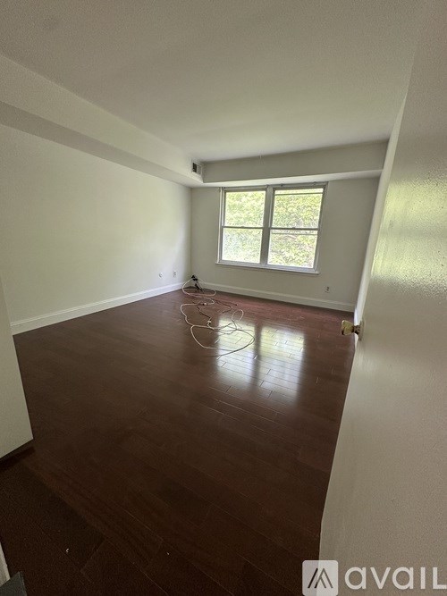 A room with wooden flooring and a window.
