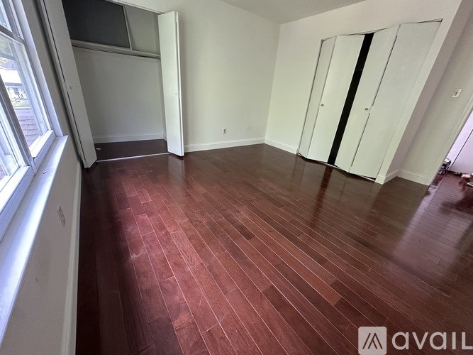 A room with wooden flooring and white walls.