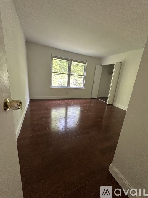 A room with wooden floors and a window letting in light.