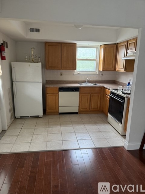 A kitchen with white appliances and wooden cabinets.