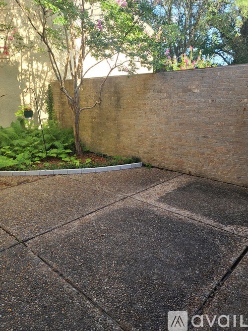 A brick wall with a tree in front of it.