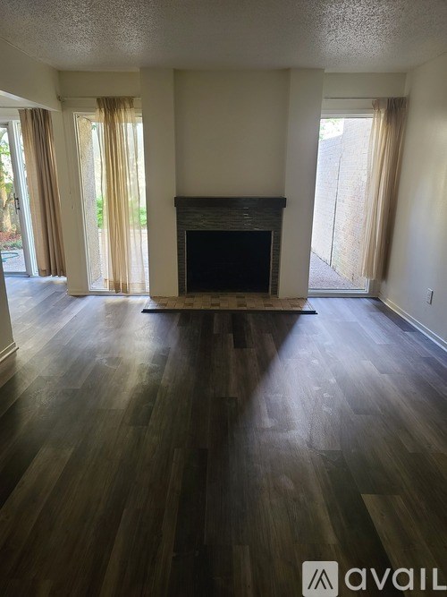 A living room with a fireplace and wood flooring.