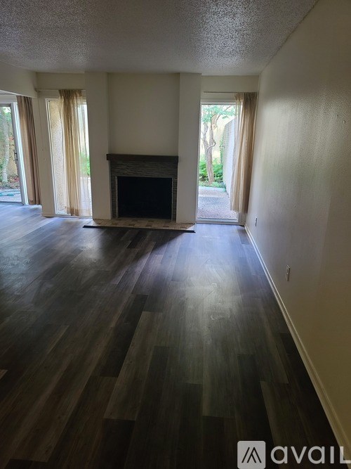 A living room with a fireplace and wood flooring.
