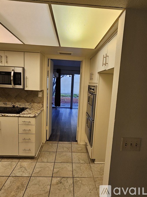 A kitchen with a microwave, oven, and sink.