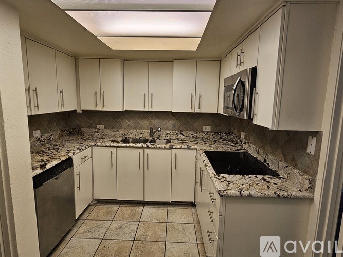 A kitchen with white cabinets and a granite countertop.