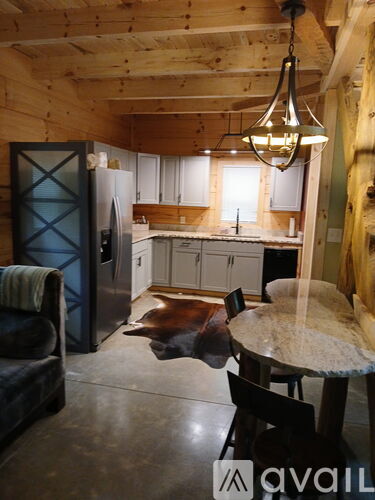 A kitchen with a table and chairs in the foreground and a refrigerator in the background.