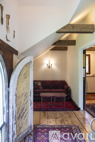 A living room with a couch and a rug.