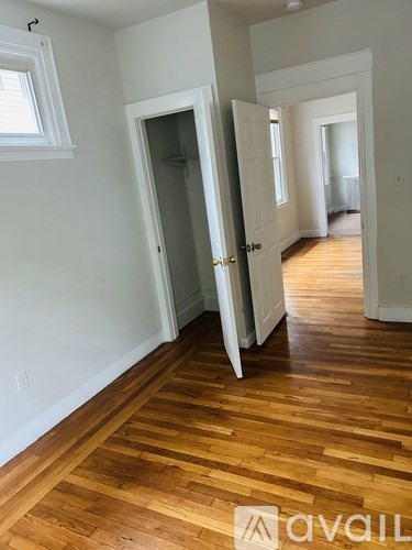 A hallway with wood floors and white walls.