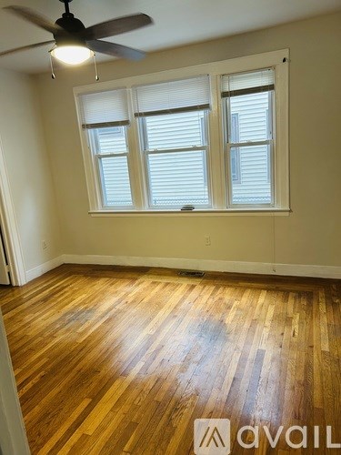 A room with wooden floors and a ceiling fan.