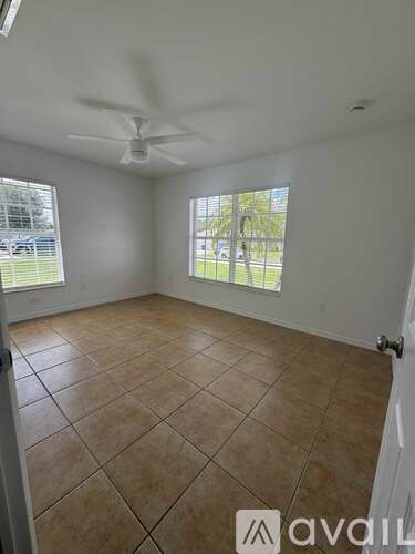 A room with a ceiling fan and tiled floor.