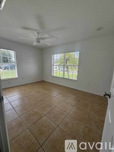 A room with a ceiling fan and tiled floor.