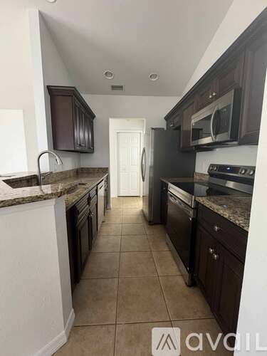 A kitchen with brown cabinets and a white door in the background.