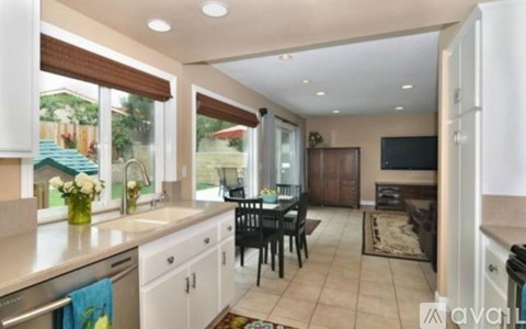 A kitchen with a dining table and chairs.