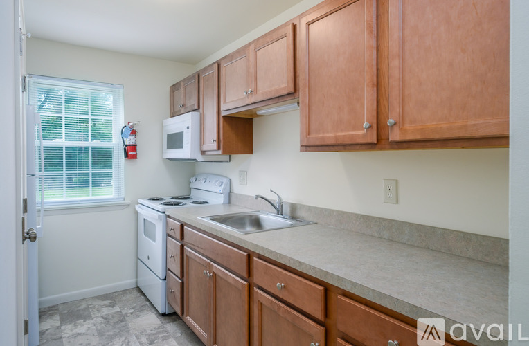 A kitchen with wooden cabinets and a white stove top oven.