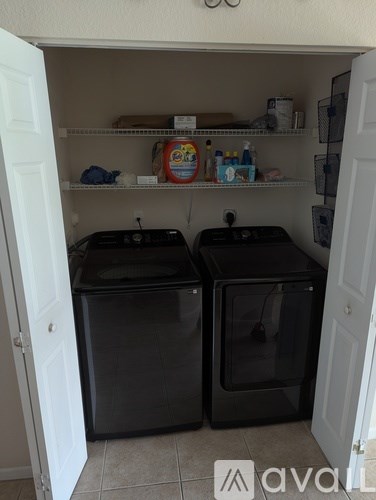 Two black ovens sit in a kitchen pantry.