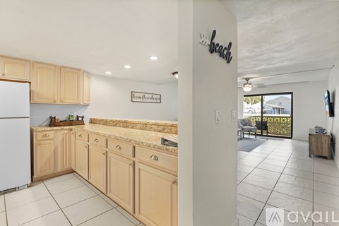A kitchen with wooden cabinets and a white fridge.