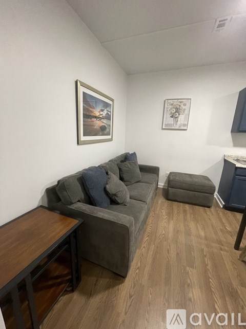 A living room with a grey couch and a wooden table.