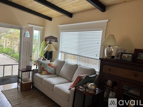 A living room with a couch, two lamps, and a table with a vase on it.
