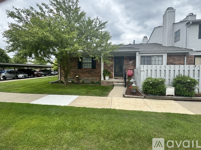 A house with a white picket fence and a brick chimney.