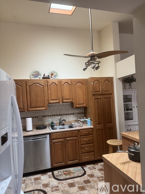 A kitchen with wooden cabinets and a tiled floor.