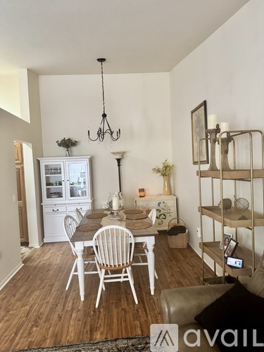 A dining room with a white table and chairs.