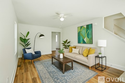 A living room with a blue rug and a blue chair.