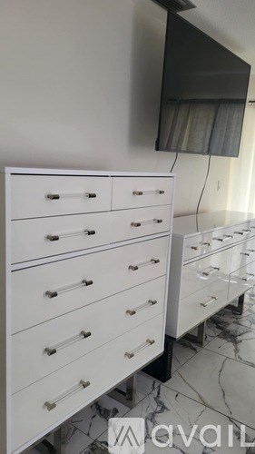 A white dresser with a mirror above it.