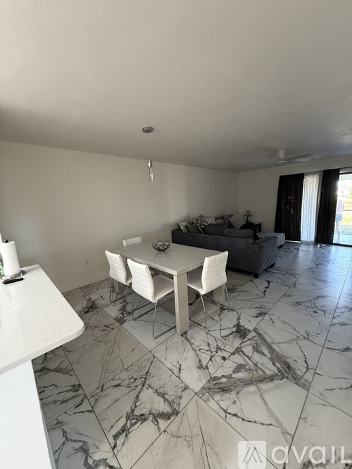 A living room with a grey couch and a marble floor.